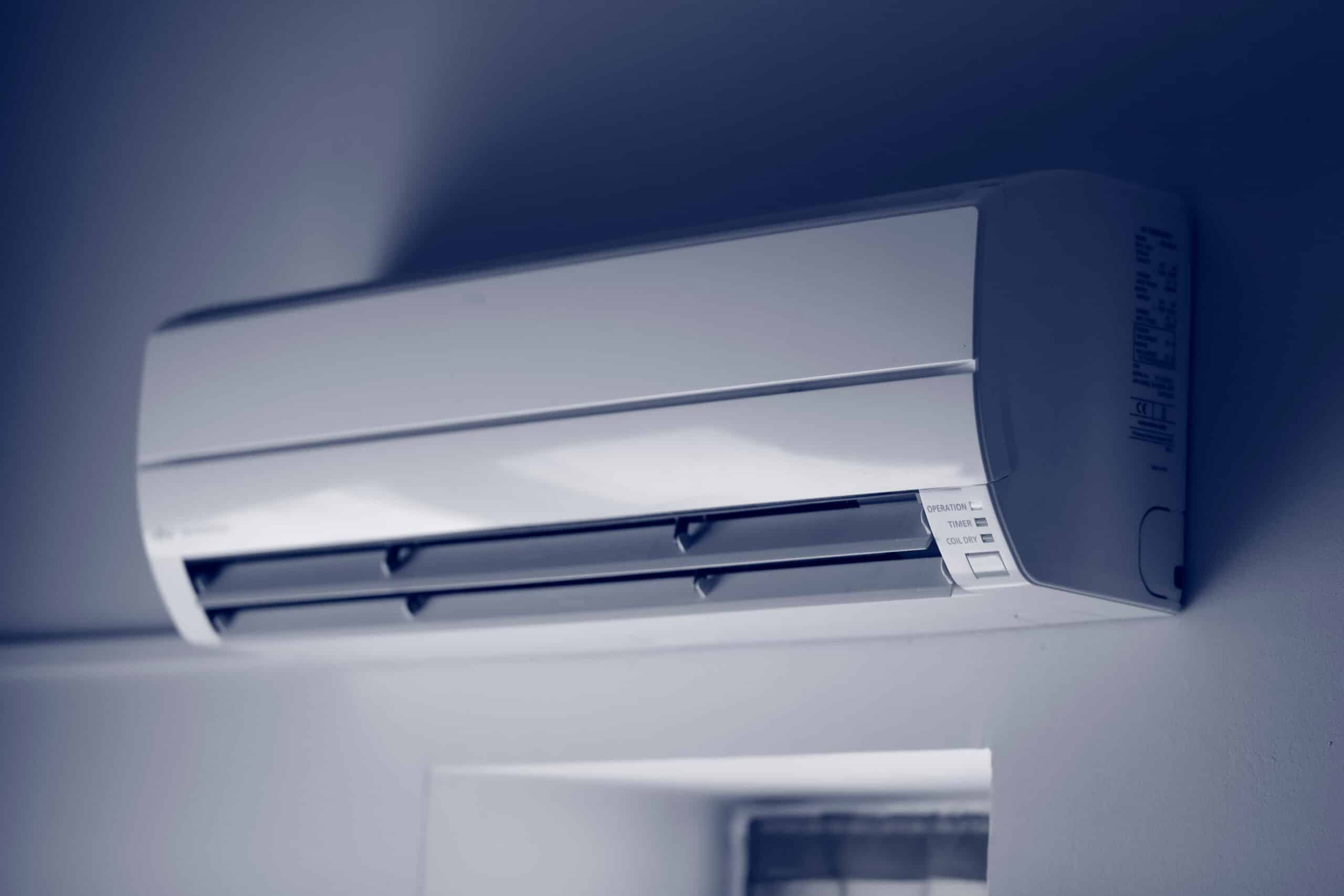 Unité intérieure de climatisation split system blanche fixée au mur. Les voyants affichent OPERATION, TIMER et COIL DRY.